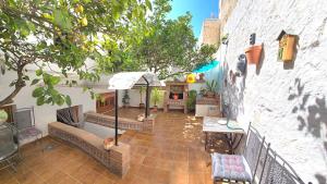 an outdoor patio with a table and a fireplace at Charming Villa in Carratraca, Malaga - 4 Bedrooms, Sleeps up to 8 Guest BY NAMASTE ELITE in Carratraca