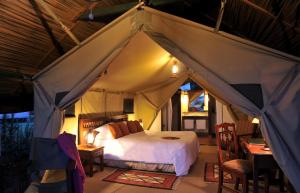 a bedroom with a bed in a tent at Sweetwaters Serena Camp in Nanyuki +24 photos