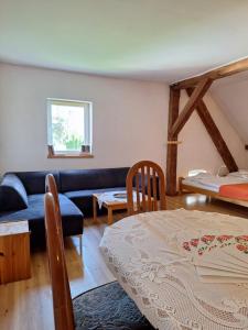 a living room with a blue couch and a bed at Folwark in Stronie Śląskie