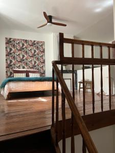 ein Schlafzimmer mit einem Bett und eine Treppe mit einem Ventilator in der Unterkunft Les Loges des Coteaux - Loge 2 - Luxury lodges with jacuzzi in Blaye + 10 Fotos