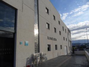 un edificio con mesas y sillas a un lado en Hotel LB Villa De Cuenca, en Cuenca