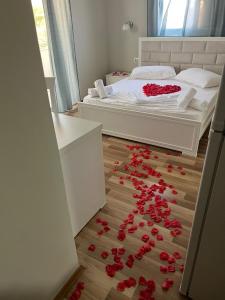 a room with a bed and roses on the floor at Dream Hotel in Ksamil +14 photos