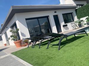 a group of picnic tables on a lawn in front of a house at Tequila House - Luxury House in Portugal in Santa Barbara +52 photos