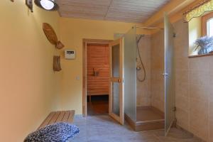 a bathroom with a walk in shower and a bench at House with sauna and jacuzzi in Jūrmala +32 photos