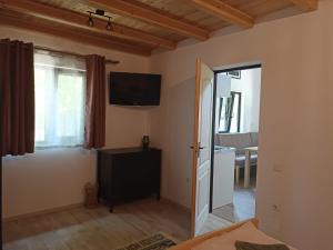 a living room with a television on the wall at Zöld Tulipán in Praid