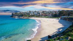 an aerial view of a beach with people on it at A modern two bedroom apartment! Quiet, secure and 1 minute walk to Bondi Beach! in Sydney