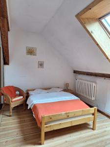 a bedroom with a bed and a chair in a attic at Folwark in Stronie Śląskie