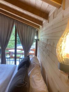 a bed in a room with a wall of windows at Bujtina Arturi in Valbonë