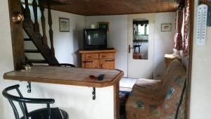 un salon avec une table et une télévision et des escaliers dans l'établissement Aux chants des oiseaux, à Heudreville-sur-Eure
