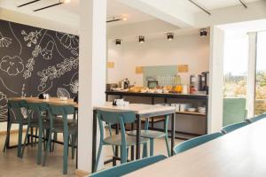 a restaurant with chairs and tables and a counter at Apart Hotel Jardín in El Calafate