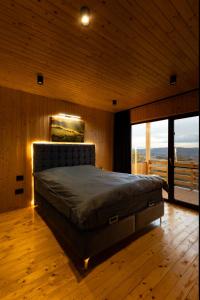 a bedroom with a bed in a room with windows at Sunset Hill Chalet Sighișoara in Sighişoara +34 photos