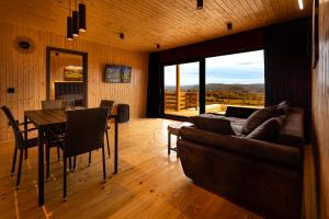 a living room with a couch and a table with a view at Sunset Hill Chalet Sighișoara in Sighişoara
