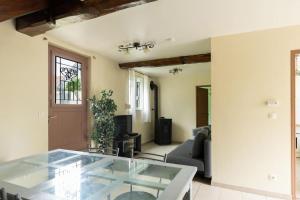 a living room with a glass table and a couch at Havre de paix idéal en famille in Monceaux