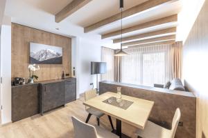 a living room with a table and a couch at Villa Hubertus Luxuria Nova Suites - Adults friendly in Naturno
