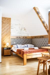 ein Schlafzimmer mit einem Bett in einem Zimmer in der Unterkunft Willa Dziubas II in Zakopane