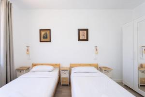 two beds in a room with white walls at Dialez Holidays - Rebecca in Playa de las Americas +36 photos