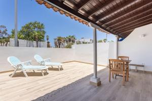 a patio with two chairs and a table at Dialez Holidays - Rebecca in Playa de las Americas