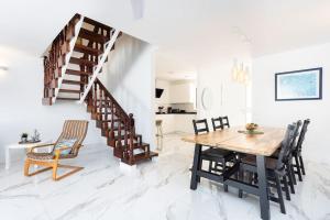 a dining room with a table and chairs and a staircase at Dialez Holidays - Rebecca in Playa de las Americas