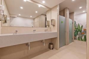 a bathroom with two sinks and a large mirror at Sunside Ibiza Studios - Only Adults- Formerly known as Central Park in San Antonio