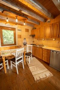 a kitchen with a table and two chairs and a counter at Całoroczne Domki "Stokrotka" in Solina