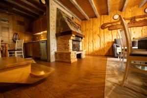 a living room with a kitchen with a fireplace at Całoroczne Domki "Stokrotka" in Solina +74 photos