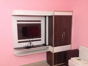 a tv sitting in a cabinet in a pink room at Hotel Viraat Inn in Gaya