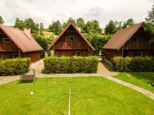 an image of a yard with two houses at Całoroczne Domki "Stokrotka" in Solina