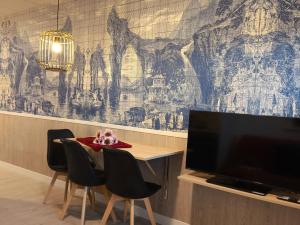 サンティアゴ・デ・コンポステーラにあるLuxury Singular Apartments Orangeのテレビとテーブルと椅子のあるリビングルーム