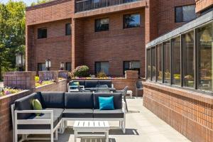 スポケーンにあるHampton Inn Spokane Airportのレンガ造りの建物の前に位置するパティオ(ソファ、テーブル付)