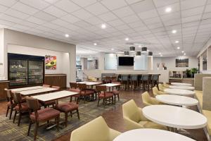 スポケーンにあるHampton Inn Spokane Airportのテーブルと椅子とバーのあるレストラン
