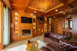 a living room with a leather couch and a fireplace at รีสอร์ท มอร์เม้าเท่น ดอยช้าง in Ban Thao Kaen Chan