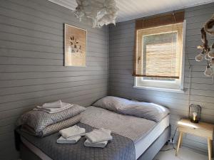 a bedroom with two twin beds and a window at Domki z jacuzzi nad zatoką in Puck