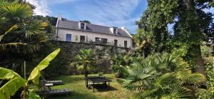 a house on top of a stone wall with palm trees at Maison ORGO in Le Palais