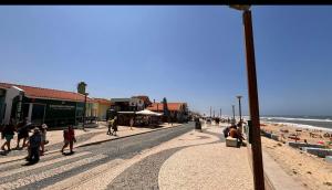 a group of people walking on the beach at Casa da alegria in Vieira de Leiria
