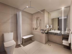 a bathroom with a toilet and a sink and a shower at Pullman Auckland Airport in Auckland