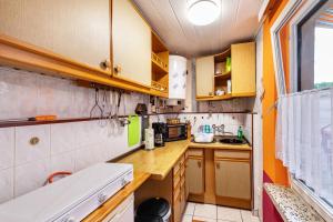a small kitchen with wooden cabinets and a window at Haus Seeblick in Malchow