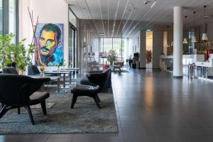 een lobby met stoelen en een schilderij van een man bij Best Western Plus Park City Malmö in Malmö