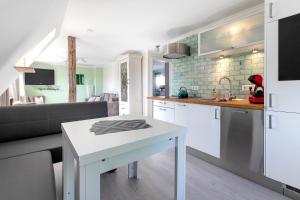 a kitchen and living room with a table and a couch at Ferienwohnung Nordfriesland in Niebüll
