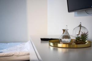 a table with a clock and a bottle on it at Brand new studio apartment near the harbour in Turku