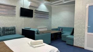 a room with a bed and a table and chairs at Sultan hotel boutique in Andizhan