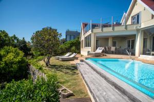 Un patio trasero con piscina y una casa. en Sunset Kiss, en Knysna