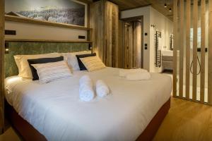 een groot wit bed met twee witte handdoeken erop bij Chalet Mussol - OVO Network in Saint-Gervais-les-Bains