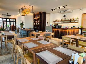 un restaurant avec des tables et des chaises en bois ainsi qu'un bar dans l'établissement Zenery Lake Resort, à Ban Don Klang 49 autres photos