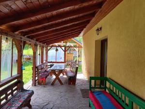 a porch of a house with benches and a table at Casa Family Time in Cavnic