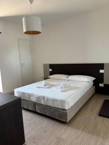 a bedroom with a large bed with white sheets at Hotel Airone in Alberobello +4 photos