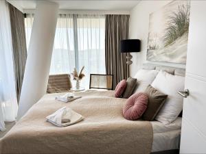 a bedroom with a large bed with a large window at Wave by Baltic Home in Międzyzdroje