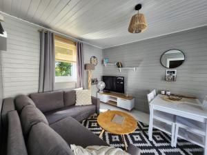a living room with a couch and a table at Domki z jacuzzi nad zatoką in Puck