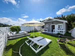 a backyard with an umbrella and a chaise lounge at Domki z jacuzzi nad zatoką in Puck