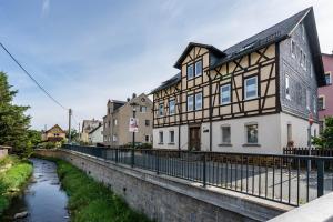 a building next to a river in a town at Ferienwohnung Familie Köhler in Thalheim