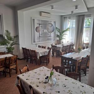 a dining room with white tables and chairs and tablesearcher at Przystań Biskupińska in Biskupin